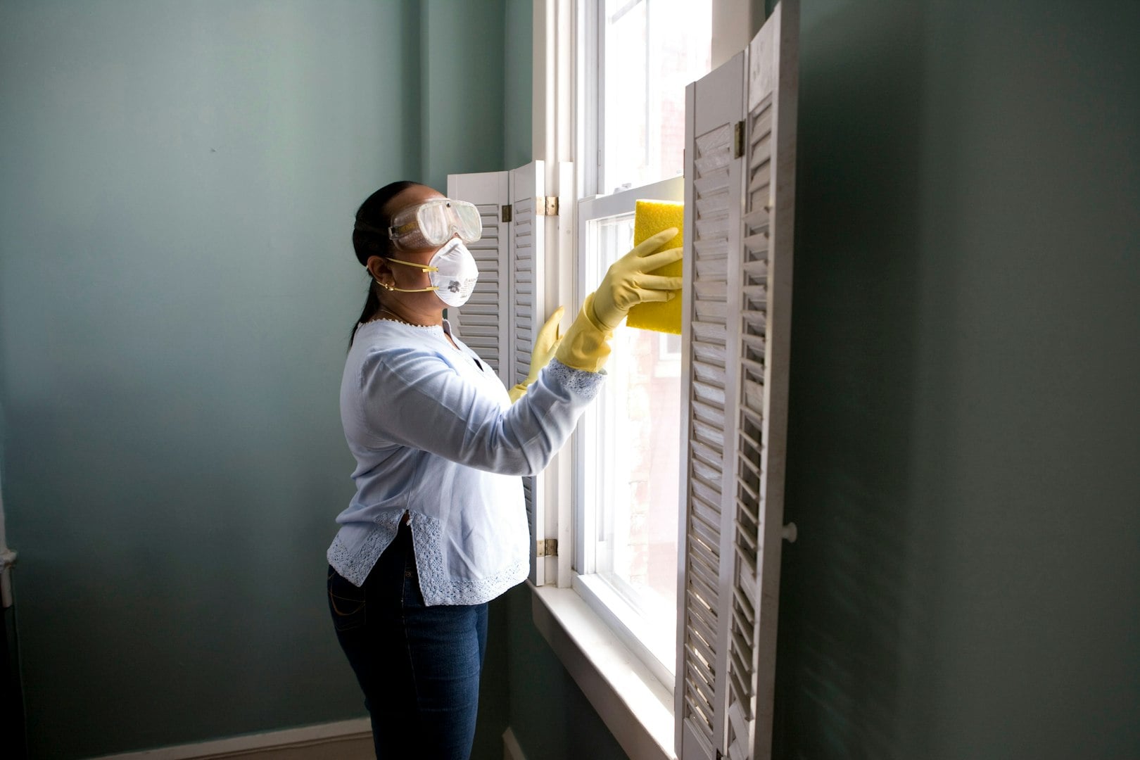 Happy diverse professional cleaners standing with arms crossed and looking at camera.